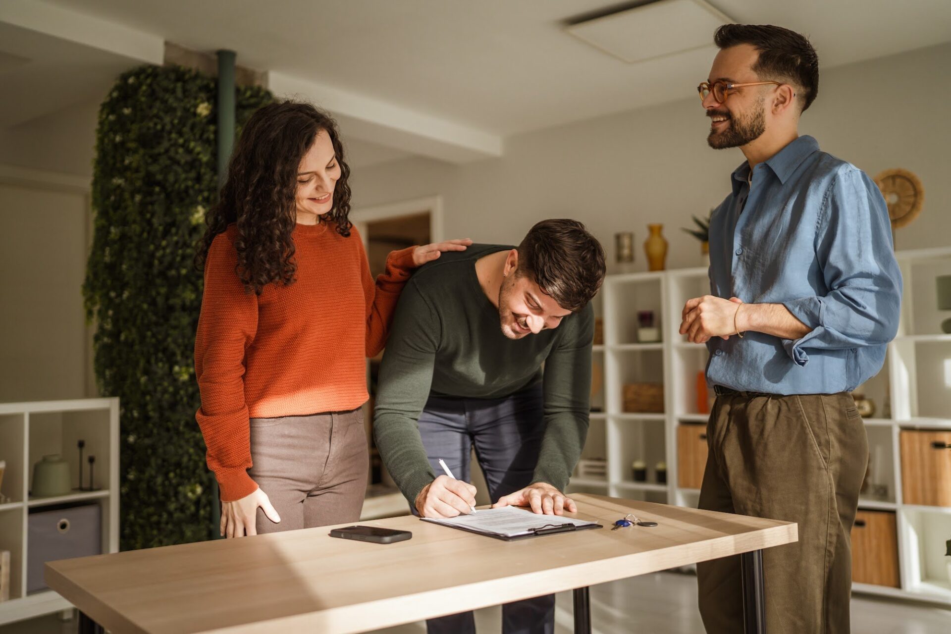 Belvoir Gloucester agent helping a couple of landlords complete property registration paperwork at a table