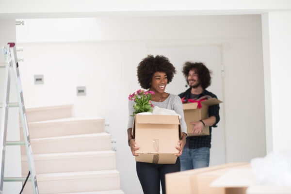 Happy young multiethnic couple unpacking or packing boxes and moving into a new home