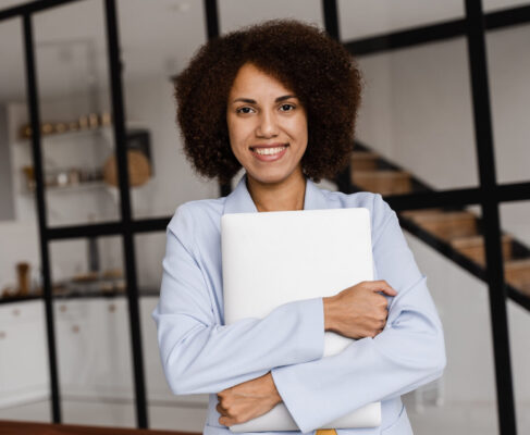Confident african woman realtor with laptop showing apartments for rent or purchase. Mortgage for flat for clients. Creative photo for real estate agency